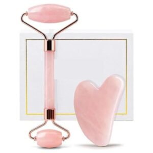 Top view of a rose quartz face massager and gua sha set on a soft fabric background