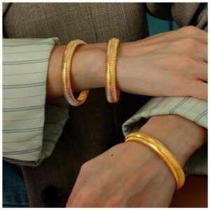 Women wearing gold bangles, showcasing the stretch design and elegance.